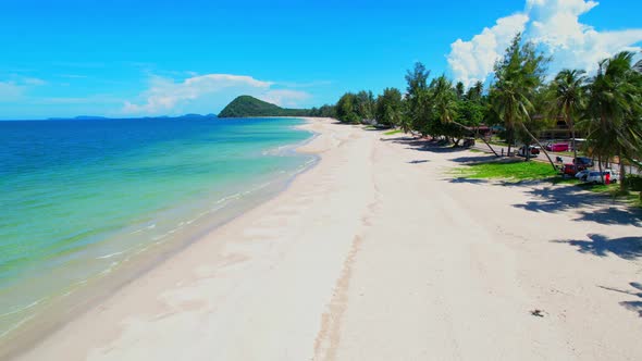 Drone flying at the tropical white beach with coconut trees