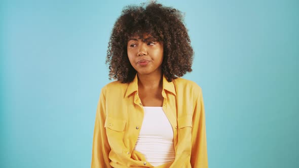 Africanamerican Young Lady Looking Around and Showing Be Quiet Hand Gesture While Posing Against