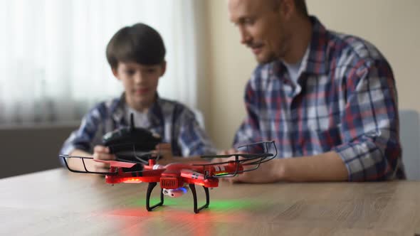 High-End Technological Toy, Little Boy Operating Quadcopter at Home, Having Fun