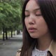 Attractive Girl Pensively Stands in the Park Against the Background of Trees - VideoHive Item for Sale