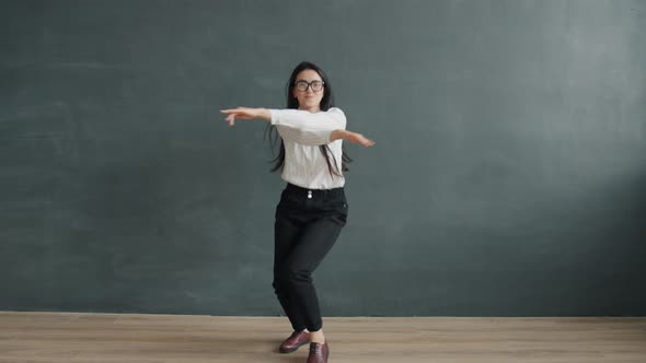 Slow Motion Portrait of Attractive Asian Girl in Formal Clothing Dancing Alone on Grey Color