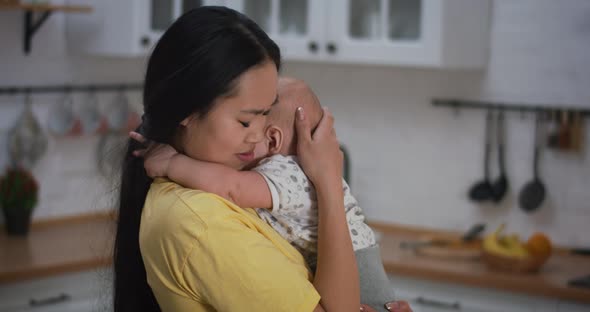 Mother Holding Crying Baby in Arms