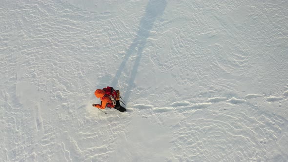 Footage  a Lone Traveler with a Backpack Walks Through the Snowy Desert