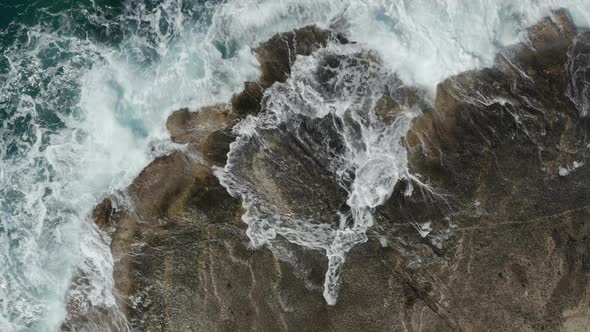 Aerial Overhead Top Down Birds Eye View of Generic Ocean Waves Crashing on Rocks