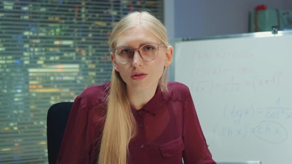 Portrait View of Blonde Woman in Eyeglasses Speaking to the Camera
