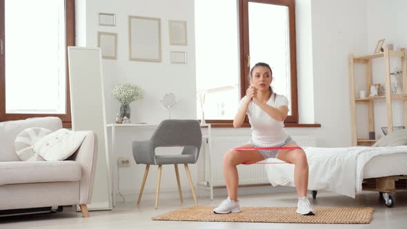 Sporty Woman Does Squats in a Room Home Fitness Exercises