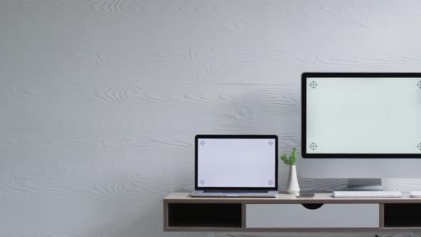 Video of computer and laptop on wooden table with copy space in office