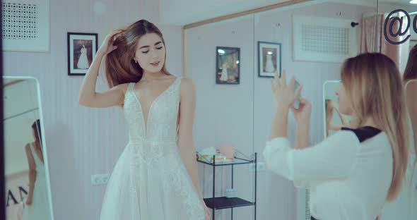 Beautiful and Happy Girl Trying on a Wedding Dress in a Luxurious Salon