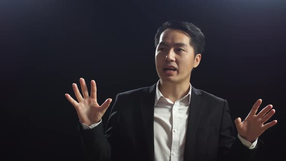 Close Up Of Asian Speaker Man In Business Suit Holding His Hands Together While Speaking