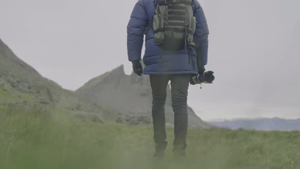 Photographer Walking Over Grass Towards Vestrahorn Mountain