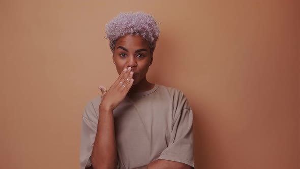 Pleased Smiling African American Woman Covers Mouth From Pleasure