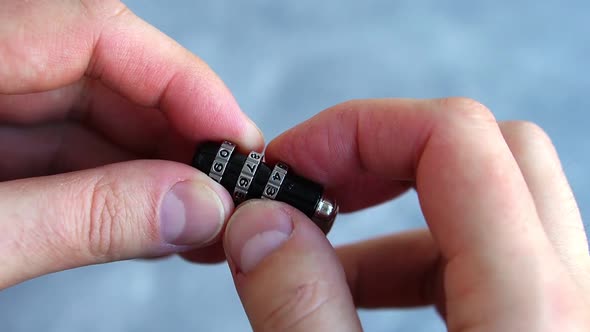 Closeup of Mans Hand Opening Combination Lock