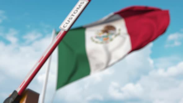 Closing Barrier with CUSTOMS Sign Against the Mexican Flag alt