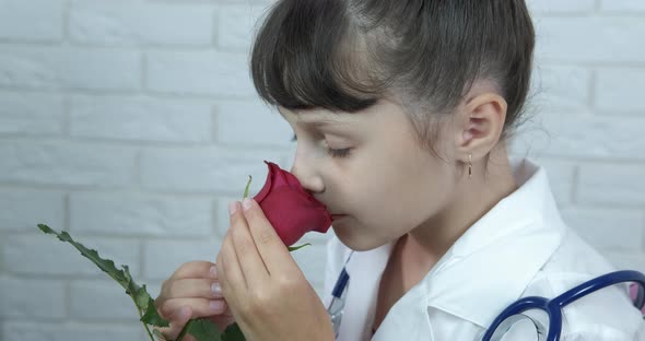 Thankful flowers for doctor. A view of a little girl doctor with a red rose in the room.