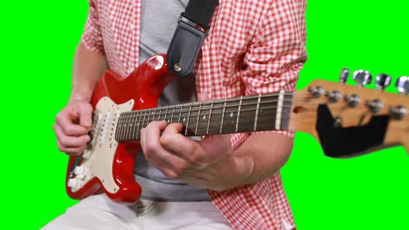 Mid section of male musician playing guitar