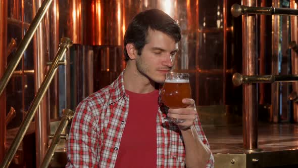 Happy Male Brewer Smelling Aromatic Fresh Delicious Beer at His Brewery 