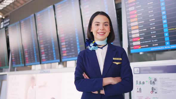 Portrait of beautiful Caucasian flight attendant staff smiling and looking at camera in airport.