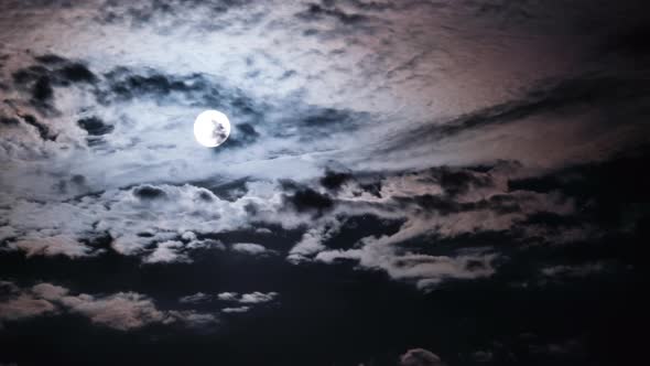 Full Moon Moves in the Night Sky Through Dark Clouds Timelapse
