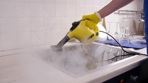 House Cleaning Concept. Man Cleaning Kitchen with Steam Cleaner