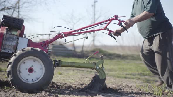 Camera Following Furrower in Male Caucasian Old Hands. Unrecognizable Mature Farmer Furrowing Soil