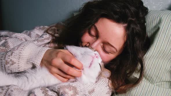 Young Girl with a Cat Basking in Bed