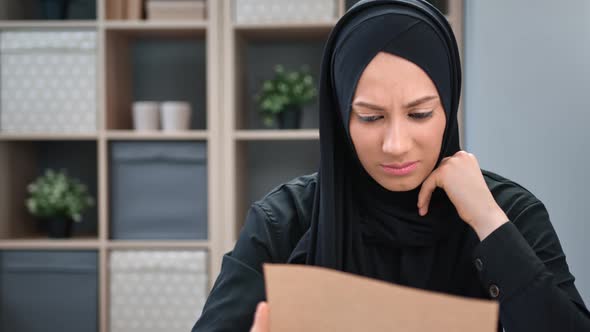 Upset Stressed Muslim Woman in Black Hijab Crying Reading Paper Letter Bad News Receiving Post Mail