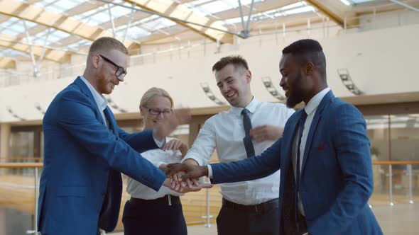 International Business Team Showing Unity with Their Hands Stacked Together in Pile