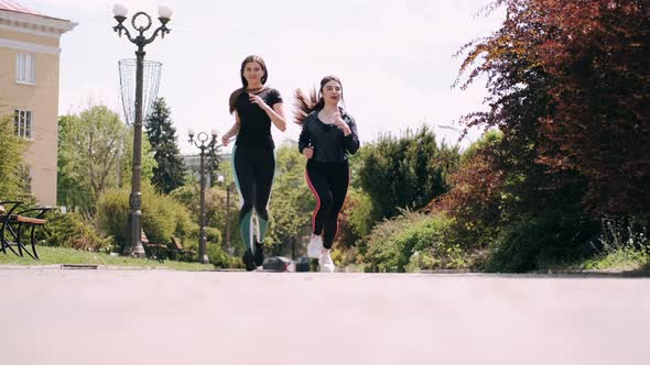 Two Sporty Women Are Jogging Together in the Morning