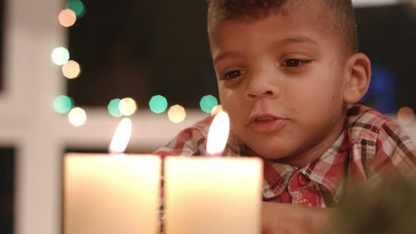 Upset Child Looking at Candle.