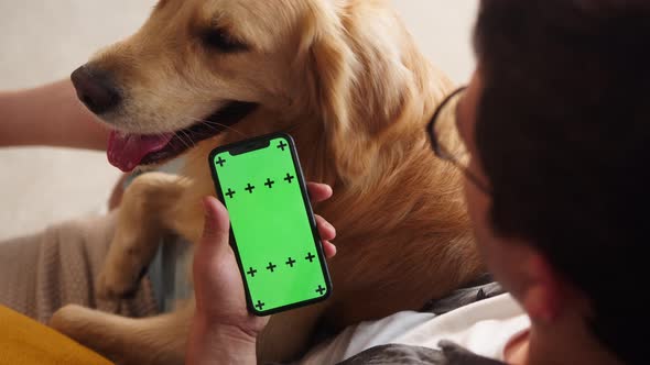 Man in Glasses Petting Golden Retriever in Livingroom