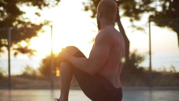 Sporty Strong Afro American Guy in Black Shorts Putting Up and Stretching Legs Making Workout on