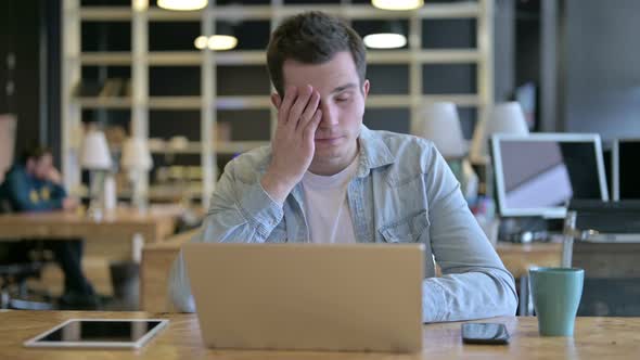 Hardworking Young Designer Having Headache in Office