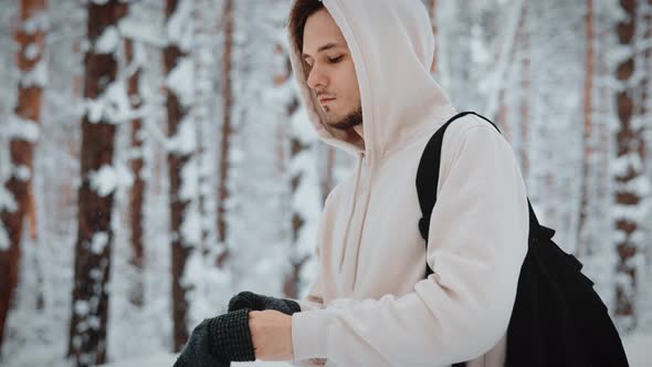 Photographer Puts on Winter Gloves in the Winter Woods