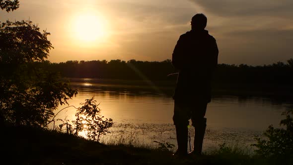 Fisherman Catches Fish on a Fishing Rod Sunset Beautifully Wraps His Silhouette