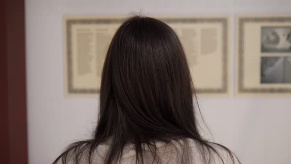 Lady Stands in National Art Gallery and Reads Information