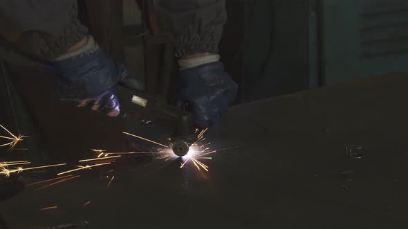 Cropped Shot of a Factory Worker Cutting Steel with Sparks Flying Around