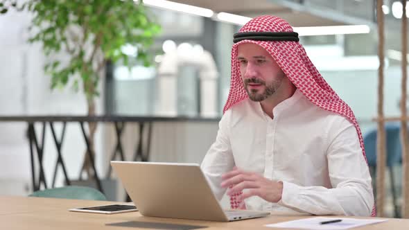 Excited Arab Businessman Celebrating Success on Laptop