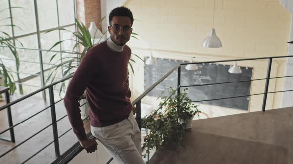 Man Posing on Mezzanine in Office