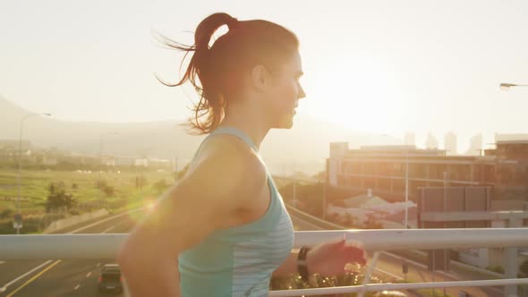 Young woman running on a bridge