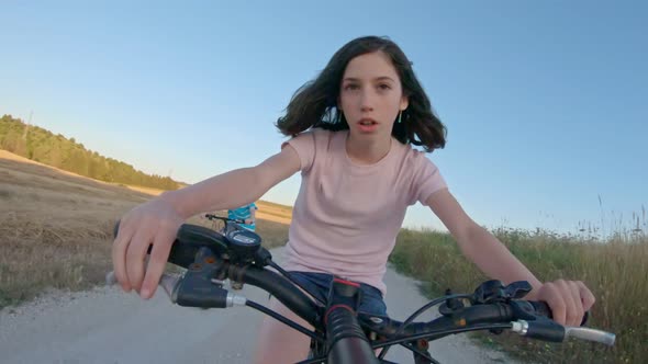 POV of a young girl enjoying a bicycle ride on the rural countryside