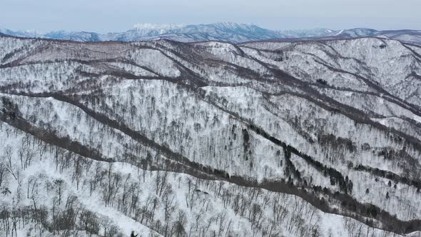 white snow mountain range peaks in winter at nozawa onsen nagano japan, aerial