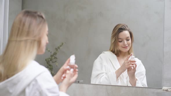 Attractive Woman Putting Bottle of Moisturizing Drops Use Beauty Product for Healthy Face Skin