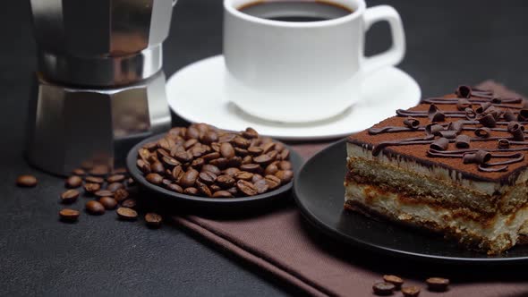 Portion of Traditional Italian Tiramisu dessert, mocha coffee maker, cup of espresso