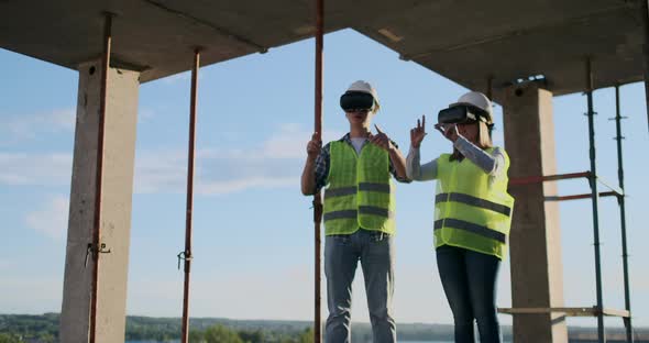 Construction Site Team or Architect and Builder or Worker with Helmets Discuss on a Scaffold