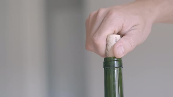 A Hand Opening a Bottle of Red Wine with a Real Cork While at Home