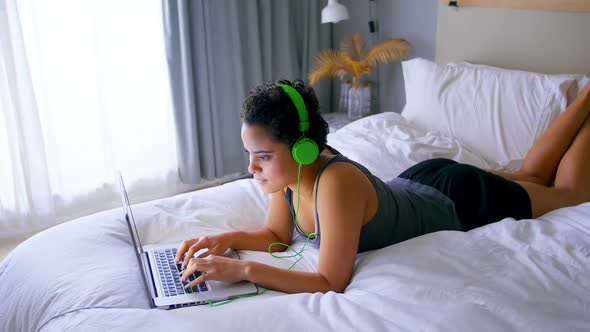 Woman working on laptop while listening to music