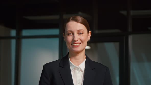 Young woman in a suit in the office, slow motion