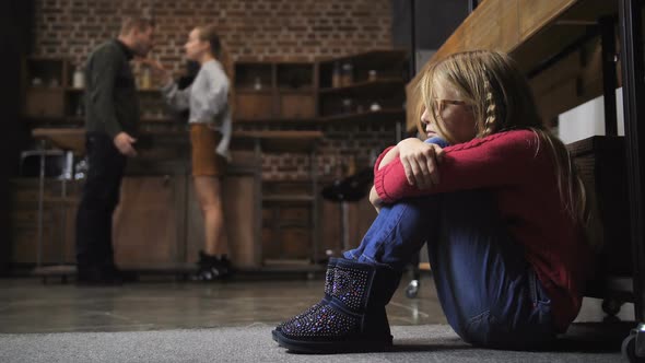 Scared Girl Sitting on Floor As Her Parents Fight