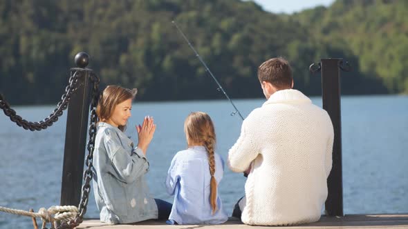 Family Sit on Pier in Autumn Day. Fall Family Portrait