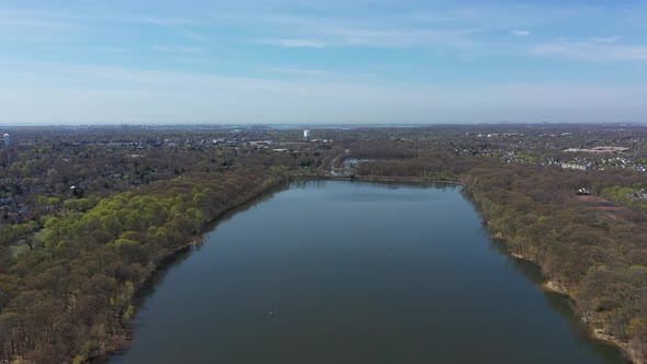An aerial view of a reflective lake during the day. The horizon is visible from this height, as the